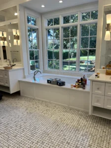 Bathroom in Greensboro featuring a large garden tub with a picture window behind and custom cabinets on either side, crafted by Borough Woodworks.