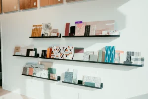 Bespoke custom shelving and storage units by Borough Woodworks in collaboration with MM Interior Design Group at Weeks Hardwood Flooring, elegantly organizing flooring samples with clean lines and functional access in a bright commercial space.