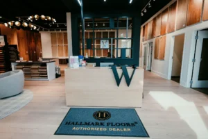 Custom reception desk crafted by Borough Woodworks for Weeks Hardwood Flooring showroom in Greensboro, featuring integrated logo engraving and durable design welcoming customers to premium flooring displays.