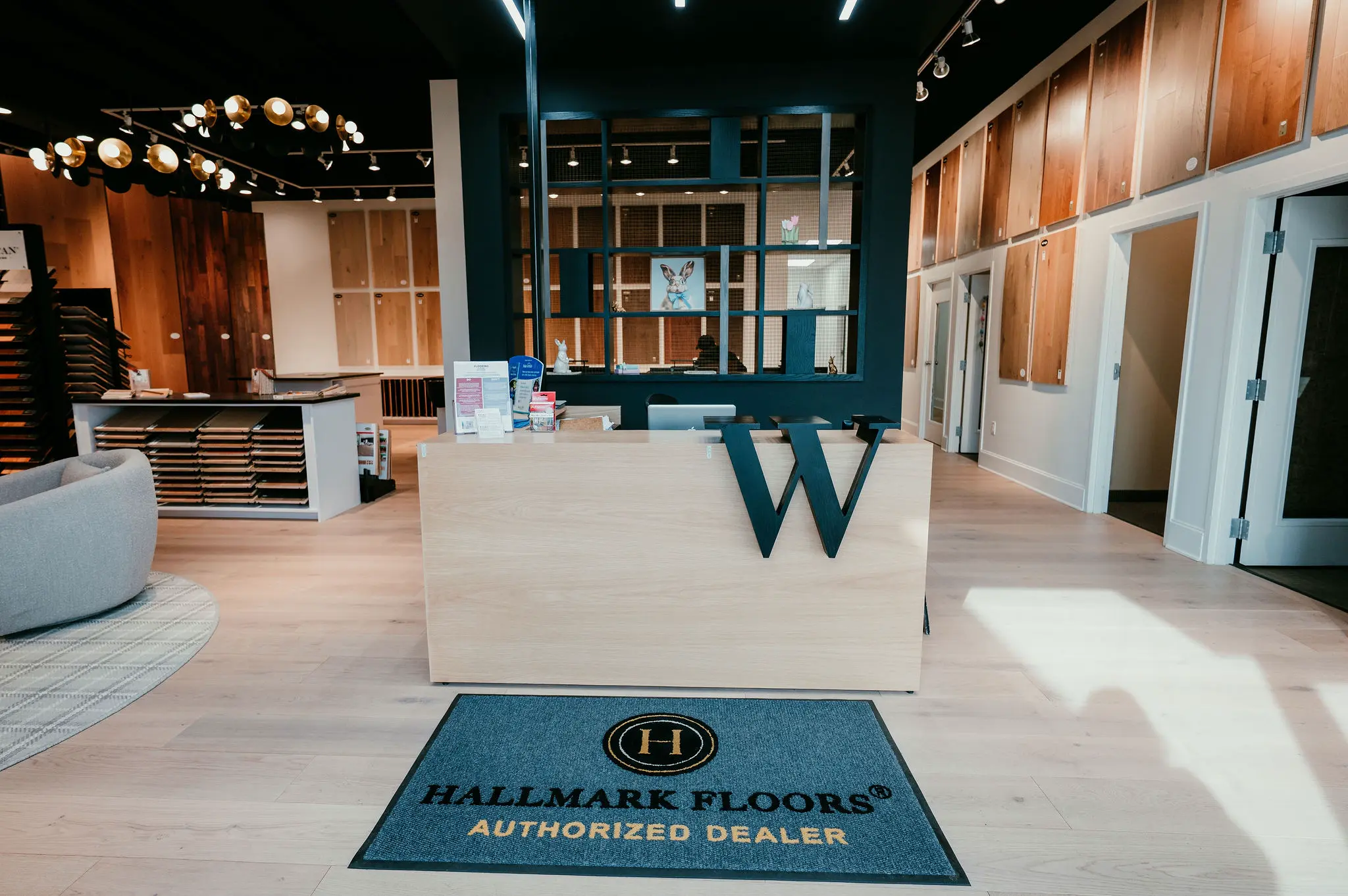 Custom reception desk crafted by Borough Woodworks for Weeks Hardwood Flooring showroom in Greensboro, featuring integrated logo engraving and durable design welcoming customers to premium flooring displays.