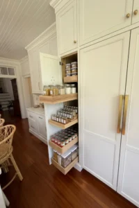 Custom full-height pantry cabinet with multiple pullout shelves for organized kitchen storage